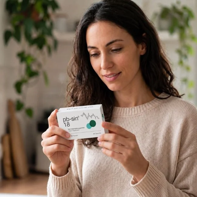 Woman looking at a pb-sin 18 package